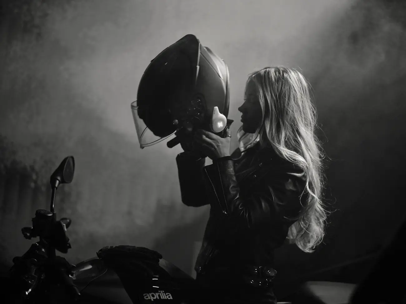 Rider lifting a helmet fitted with the Rogue